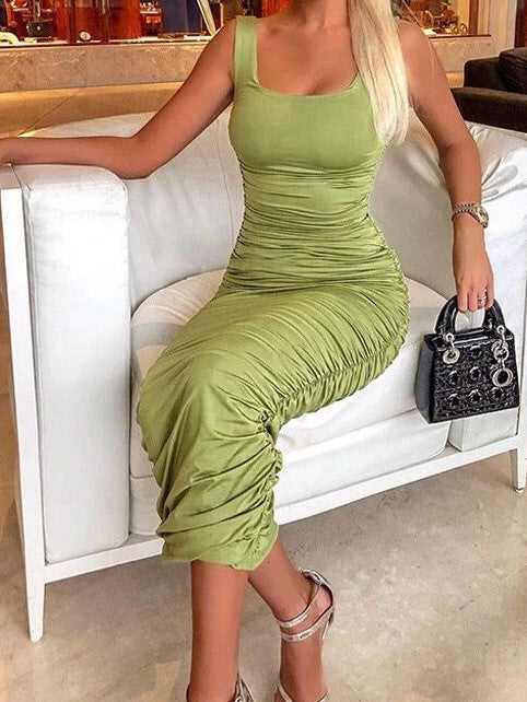 Woman wearing light green ruched bodycon midi dress. 